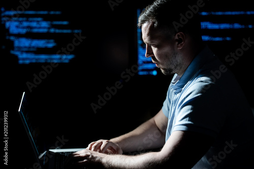 Fotografia Hacker types code on laptop keyboard