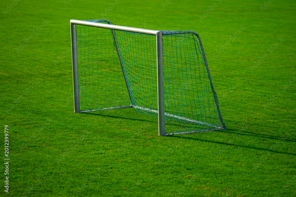 Fototapeta premium Football field shows empty goalpost. Football field with netting pattern. Football field supports training concept. Football field fits stadium environment.