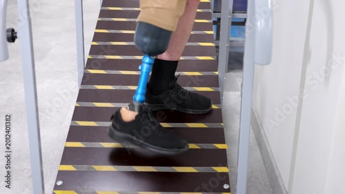 Amputee with prosthetic leg walking uphill for rehabilitation