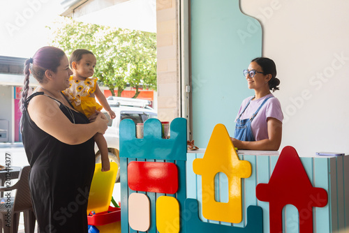 Fotografía Two adult women and a baby entering a colorful early childhood stimulation cente
