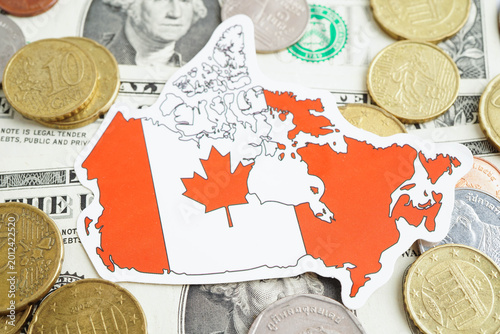 Canada flag on coin and banknote money, finance trading investment business currency concept.