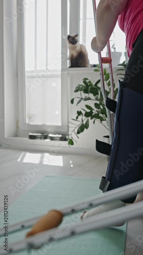 Woman with broken leg and crutches at home