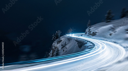 Winding Snowy Mountain Road at Night with Light Trails
