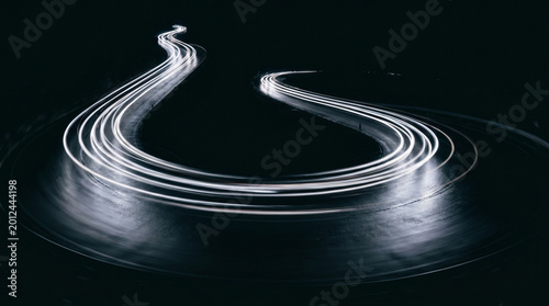 Abstract light trails of a winding road at night, a dynamic visual