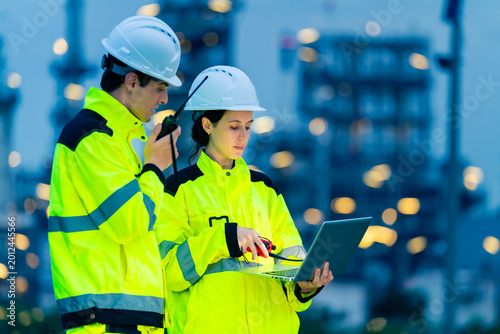 Fotografie Petroleum refinery engineers and industrial workers working on laptop computer,