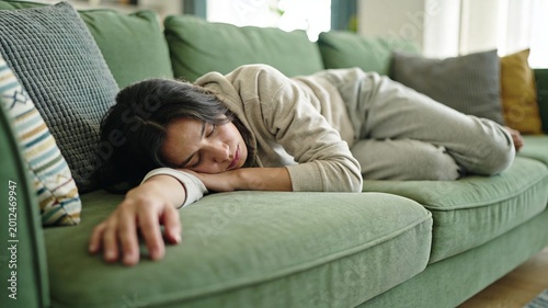 Tired woman lying on a green couch