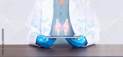 Photos Doctor examining knee bones on a tablet, telemedicine platform