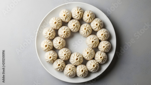 Steamed green dumplings arranged in a circle on a plate