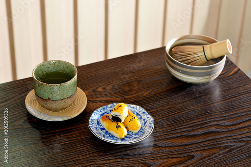 Chinese pastry and Japanese Matcha hot tea on wooden table