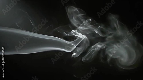 Smoke rises from burning object on dark background with fog