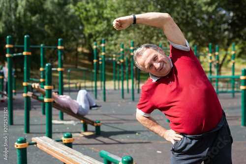 Εκτύπωση καμβά elderly man does gymnastics on an outdoor sports ground.