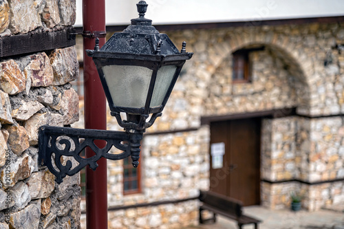 Lamp post stands near stone wall in Skopje, North Macedonia on a clear day