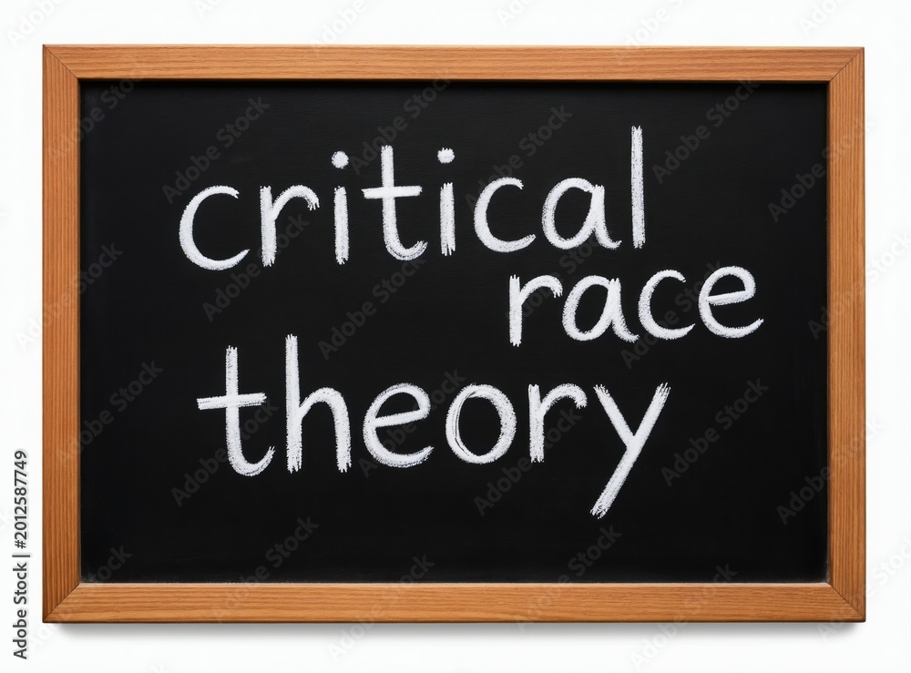 Fototapeta premium Critical race theory text in white chalk on a black chalkboard. Simple phrase conveys academic concept. Educational tool for learning social justice ideas.