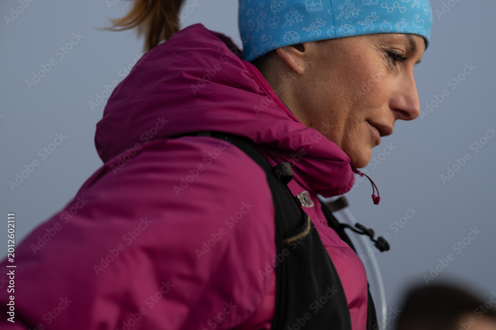 Fototapeta premium Determined Woman Hiker In Pink Jacket And Blue Beanie Outdoors On A Cold Morning Hike