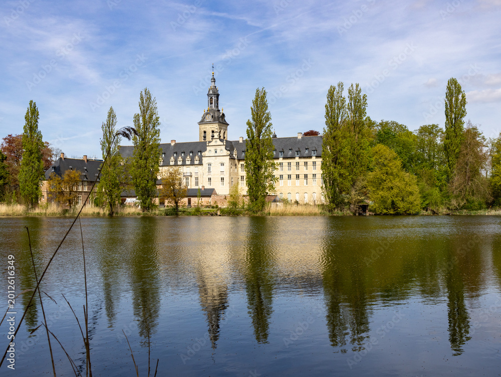 Obraz premium Historic Park Abbey near Leuven Belgium reflected in tranquil lake with spring trees