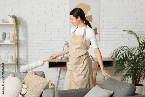 Young woman cleaning room w...