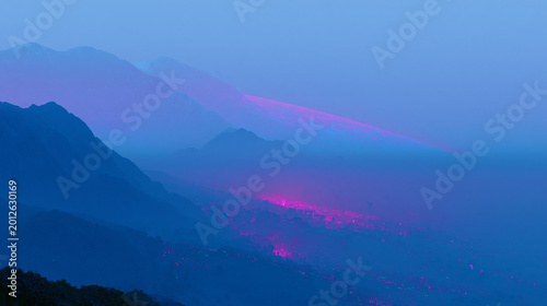 Neon Light Trails Across Misty Blue Mountain Valley