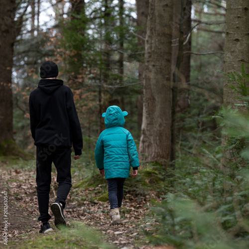 Foto Walking through a tranquil forest trail, two children immersed in nature on a co