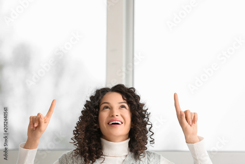 Valokuva Young businesswoman pointing at something near window in office