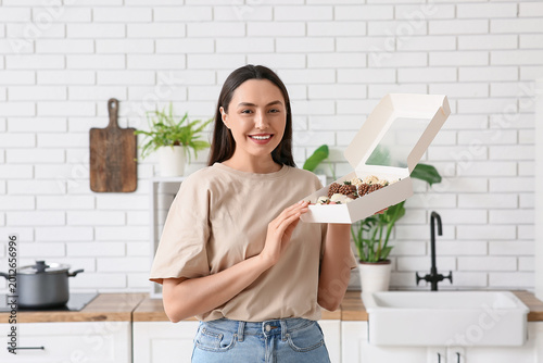 Happy young woman holding b...