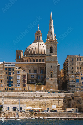 Tall church spire and dome in historic Valletta city center