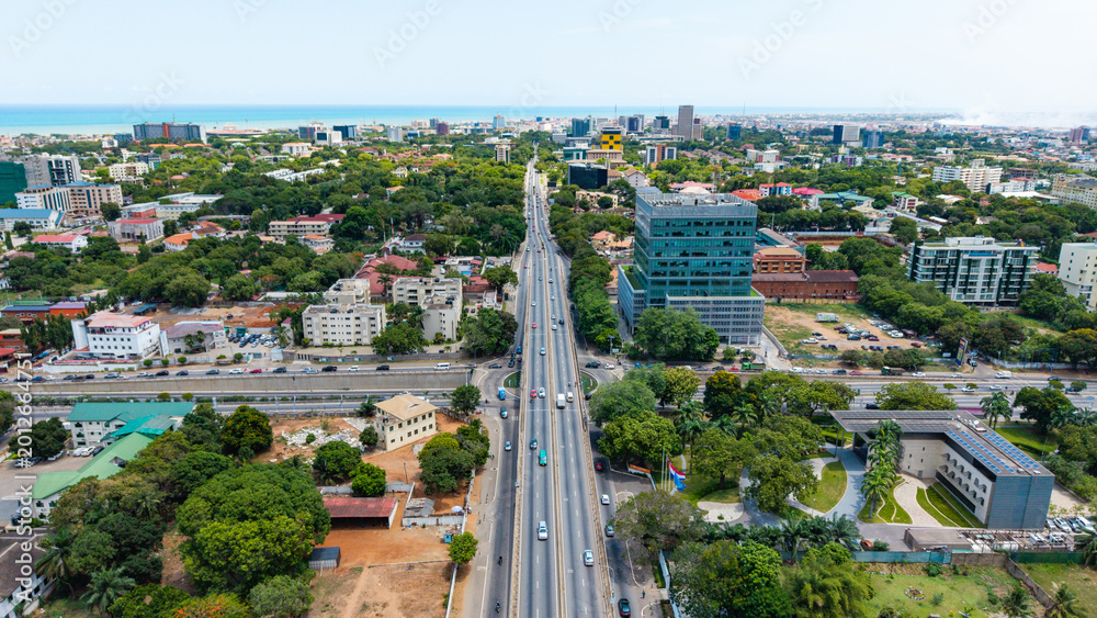 Naklejka premium Aerial view of Accra ghana cityscape featuring busy roads, buildings, and green trees