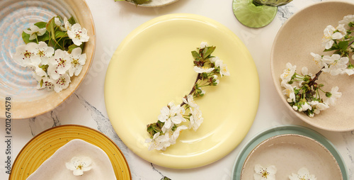 Foto Different clean plates with blooming branches on white background