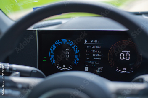 Long-Term Vehicle Telemetry. Digital gauge cluster tracks accumulating over 2000 mi since initialization. Brilliant electric blue arcs sweep across modern matte black dash materials