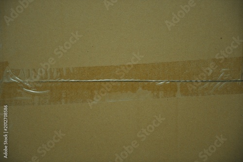 a brown closed carton with transparent tape