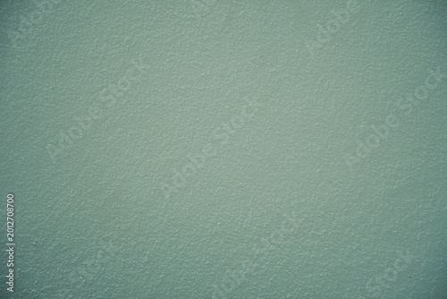 a greenish wall with different texture and color