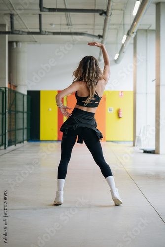 Dancer in sportswear performing a routine in a large hall