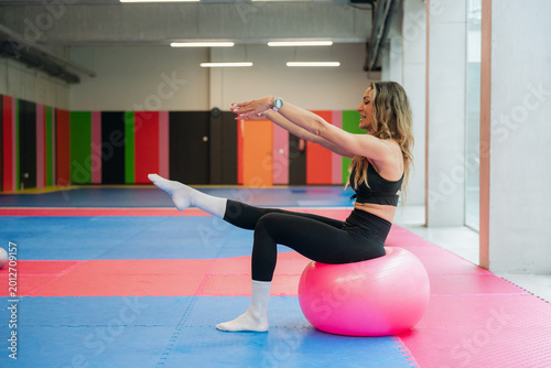 Woman exercising on stability ball in gym
