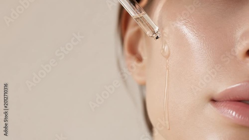 Macro close up of woman face with cosmetic serum dropper and glowing skin, luxury skincare treatment, beauty wellness concept.