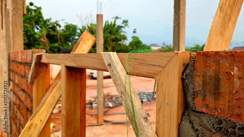 Tablou pe pânză Brick Wall Construction with Wooden Formwork, Building Site in Progress