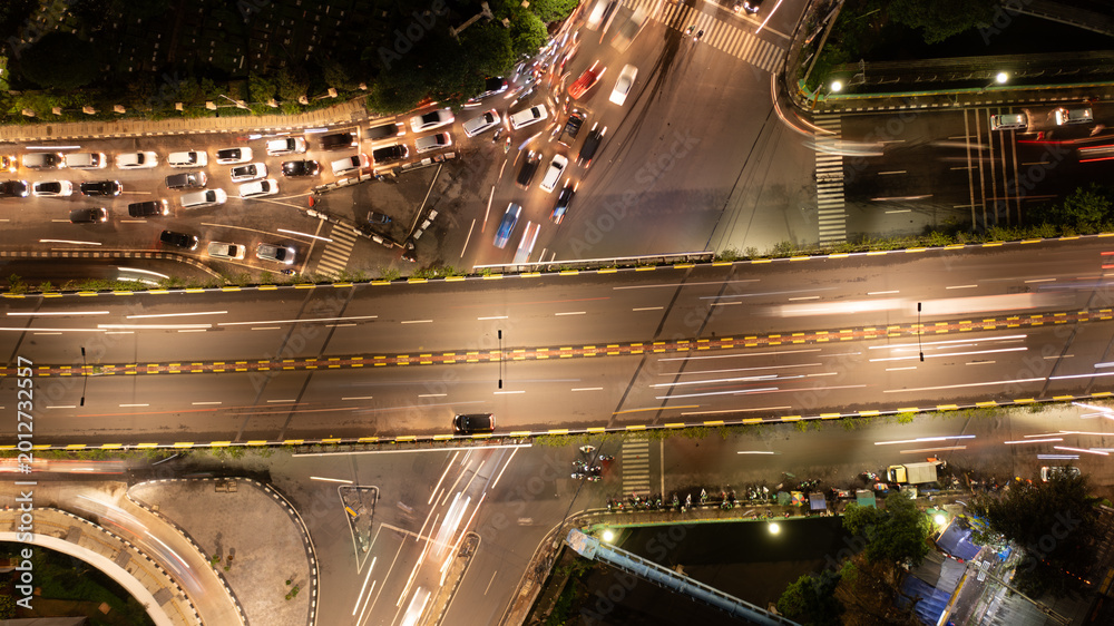 Fototapeta premium Aerial Top View of Busy City Traffic Jam and Light Trails on Flyover at Night