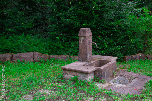 Cuadro en lienzo an old rustic stone water fountain dispensing fresh natural spring water surroun