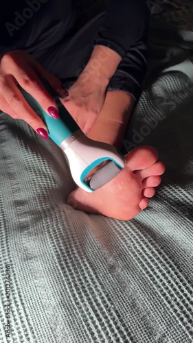 Close-up of foot being exfoliated with handheld tool