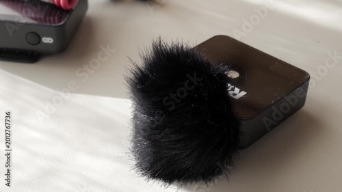 Lavalier mic with furry cover on white table, intimate indoor setting