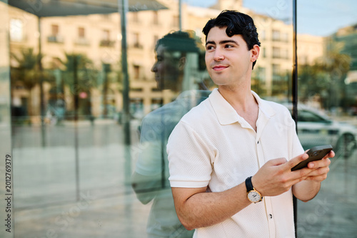 Photos Portrait of a young man guy using a phone in the street