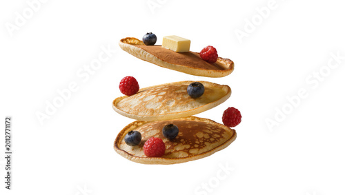 Stack of three golden pancakes with butter raspberries and blueberries, isolated on transparent background