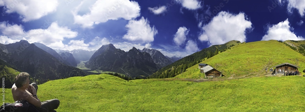 © Michael Rucker/imageBROKER - Hiker, panoramic view of a verdant alpine pasture set against a deep blue sky, Ahornboden, Tirol, Austria, Europe © Michael Rucker/imageBROKER - Hiker, panoramic view of a verdant alpine pasture set against a deep blue sky, Ahornboden, Tirol, Austria, Europe