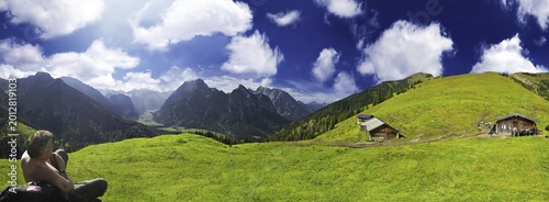 Hiker, panoramic view of a verdant alpine pasture set against a deep blue sky, Ahornboden, Tirol, Austria, Europe