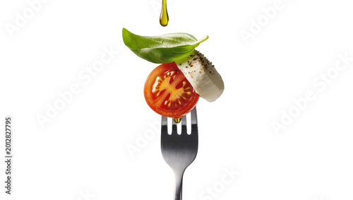 Konstfotografi Fresh tomato slice mozzarella cheese and basil leaf on fork, isolated on transpa