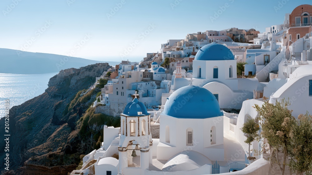 Fototapeta premium Iconic white buildings and blue domes overlook the sparkling Aegean Sea in picturesque Santorini, Greece