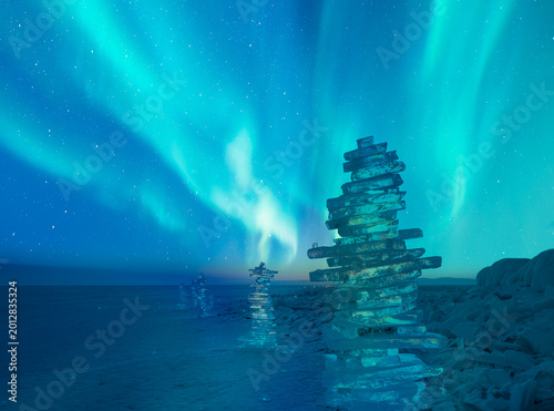 Beautiful winter landscape of frozen Lake Baikal with Aurora Borealis - Snowy ice hummocks with transparent blue piles of ice - Baikal Lake, Siberia
