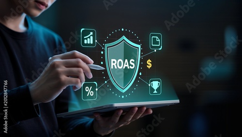 Businessman holding tablet with digital shield displaying ROAS and financial growth icons concept