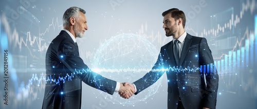 Two professional businessmen shaking hands with digital financial data and global network hologram