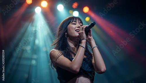 ステージで力強く歌い上げる日本人女性ボーカル、ライブの熱気が伝わる音楽写真