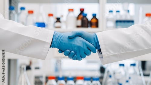 Medical professionals shaking hands in laboratory setting representing collaboration and healthcare partnership in a clinical environment with scientific equipment and supplies