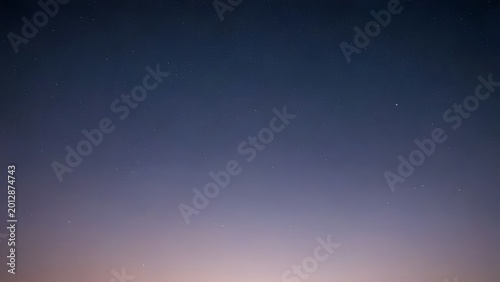 Deep twilight sky gradient with faint stars and distant city glow in a serene atmospheric vista